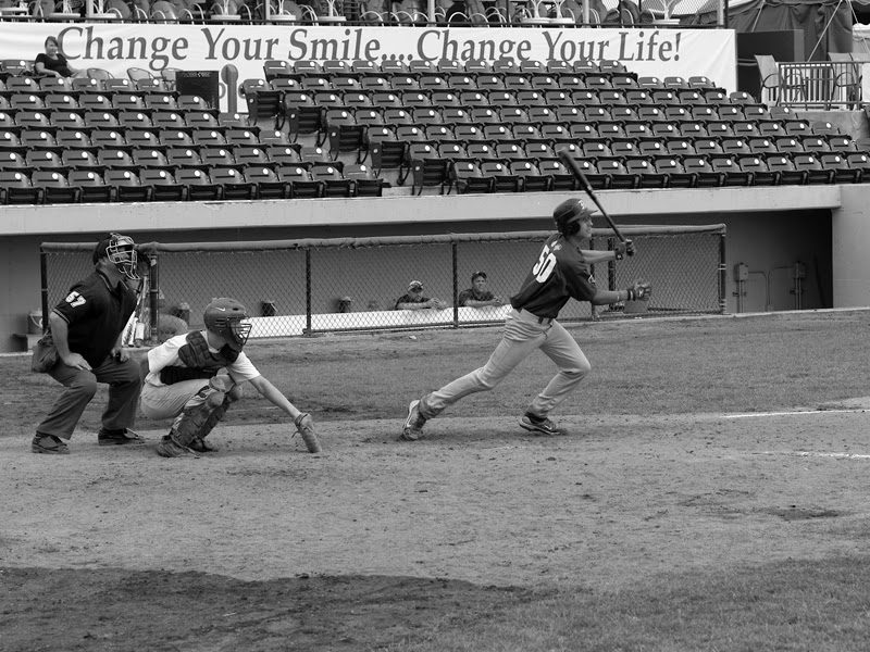 Austin batting for Cubs RBI. Background sign: “Change Your Smile… Change Your Life!”